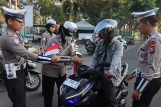 Aksi Simpatik Menyambut HUT RI ke-80, Polisi Bagikan Bendera Merah Putih Kepada Pengendara di Pamekasan