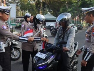 Aksi Simpatik Menyambut HUT RI ke-80, Polisi Bagikan Bendera Merah Putih Kepada Pengendara di Pamekasan